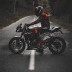 man in white and red jacket riding black sports bike on road during daytime